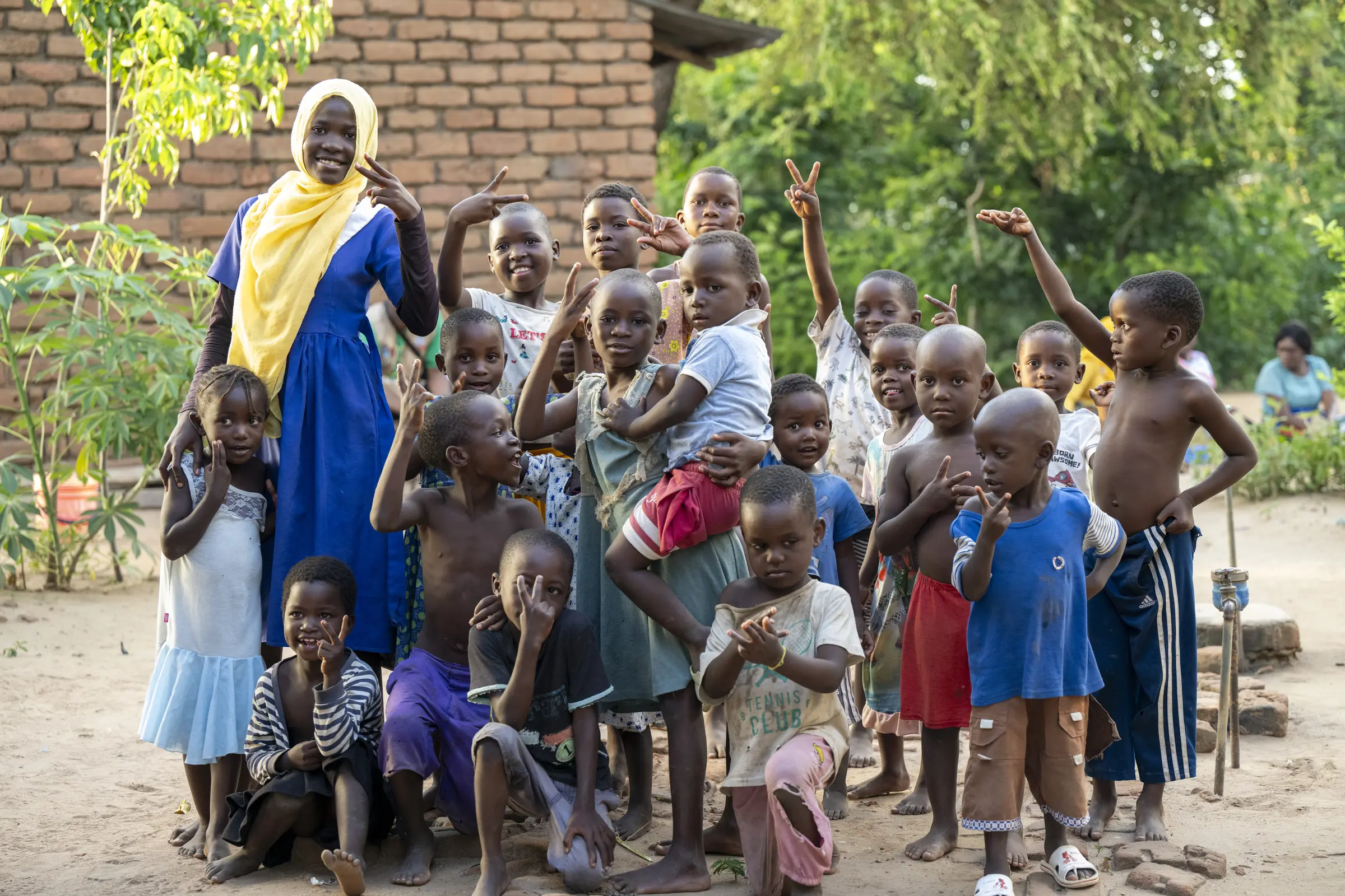 A woman and children gathered for a portrait in a Malawi village