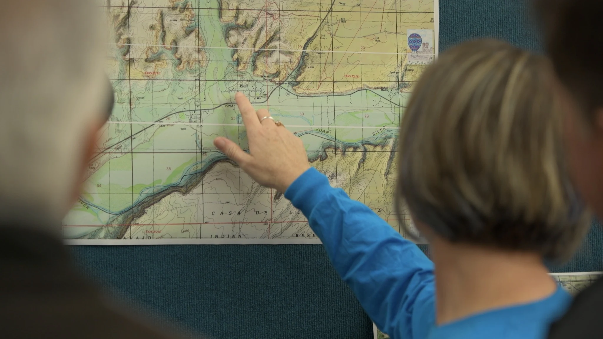 A hand points to Bluff on a topographic map.