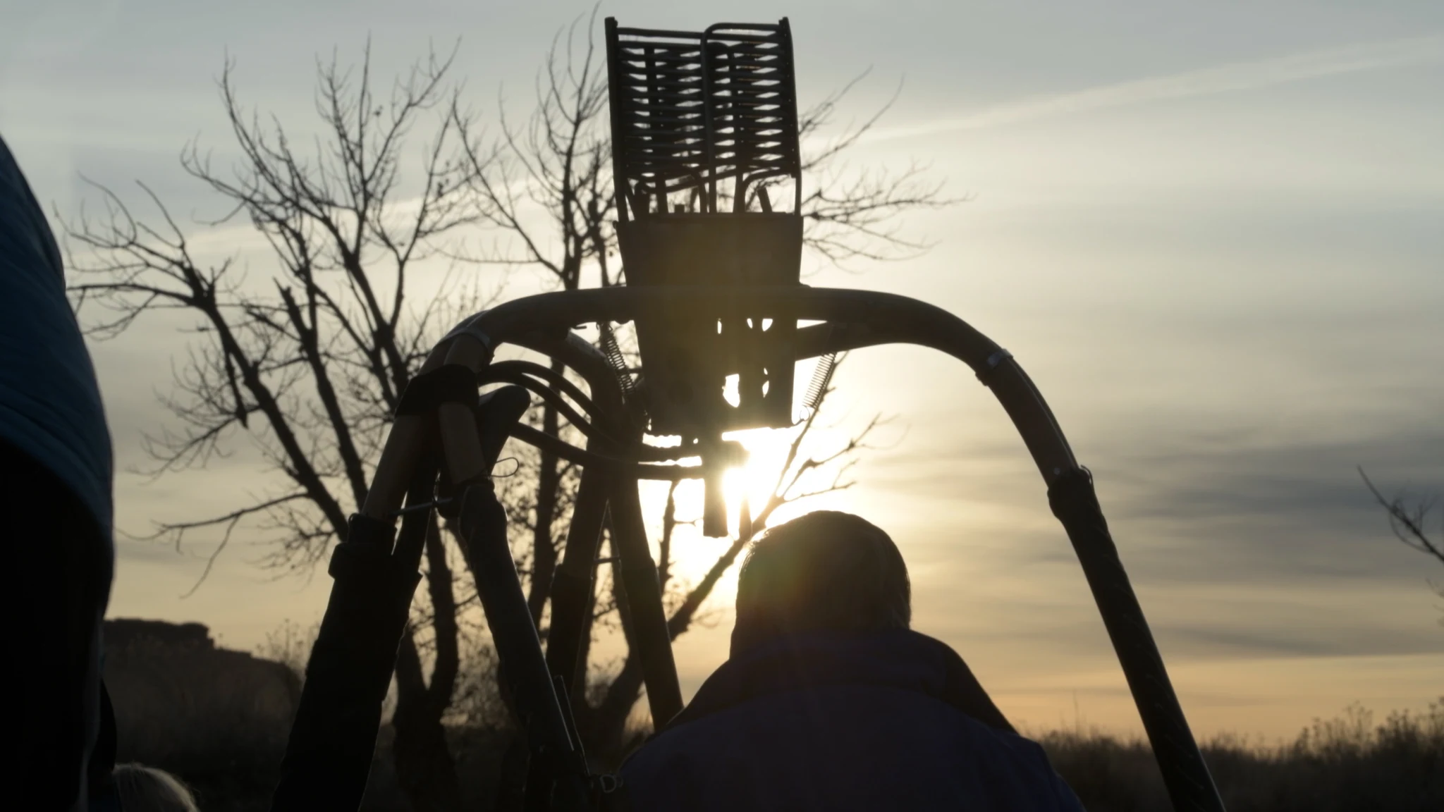 A balloon burner silhouetted against the low winter sun.