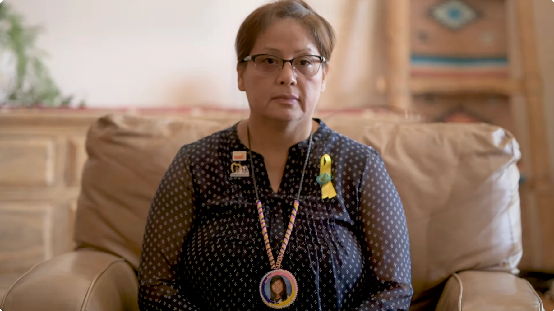 Pamela Foster seated for an interview, wearing Ashlynne’s portrait pendant.