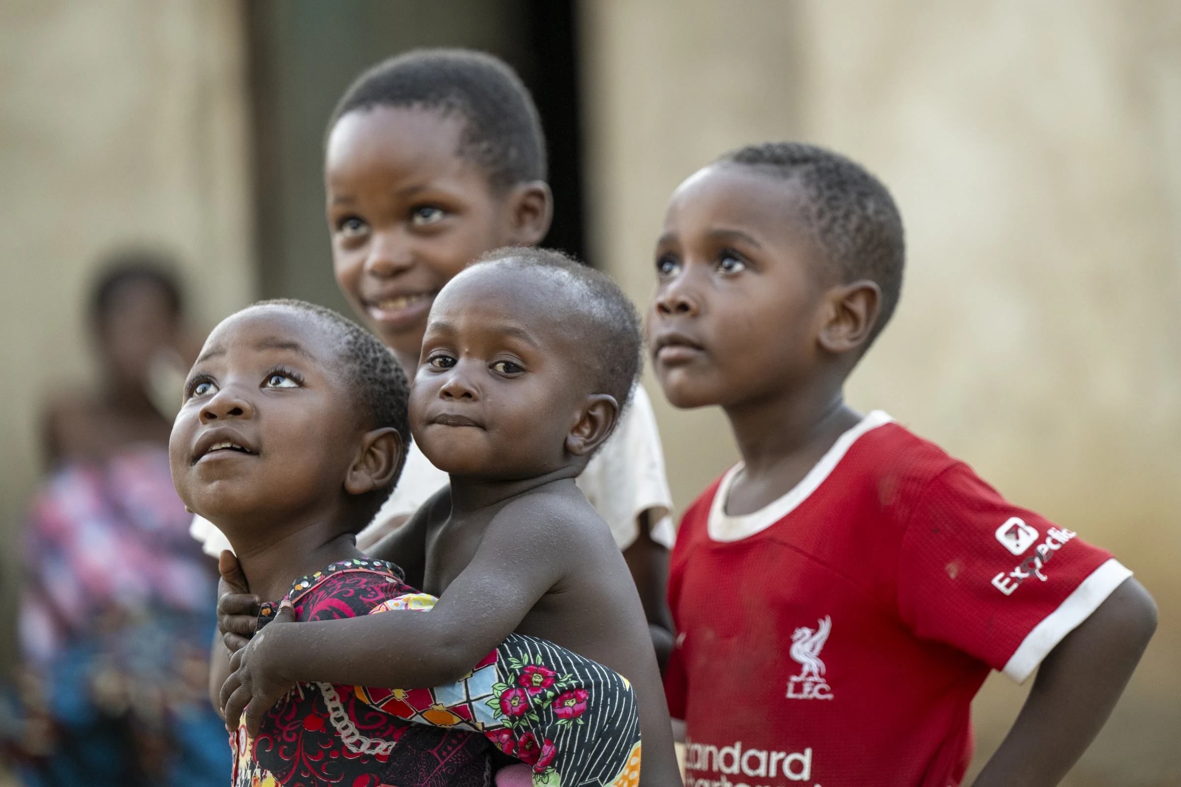 Children gathered together, looking upward in Malawi