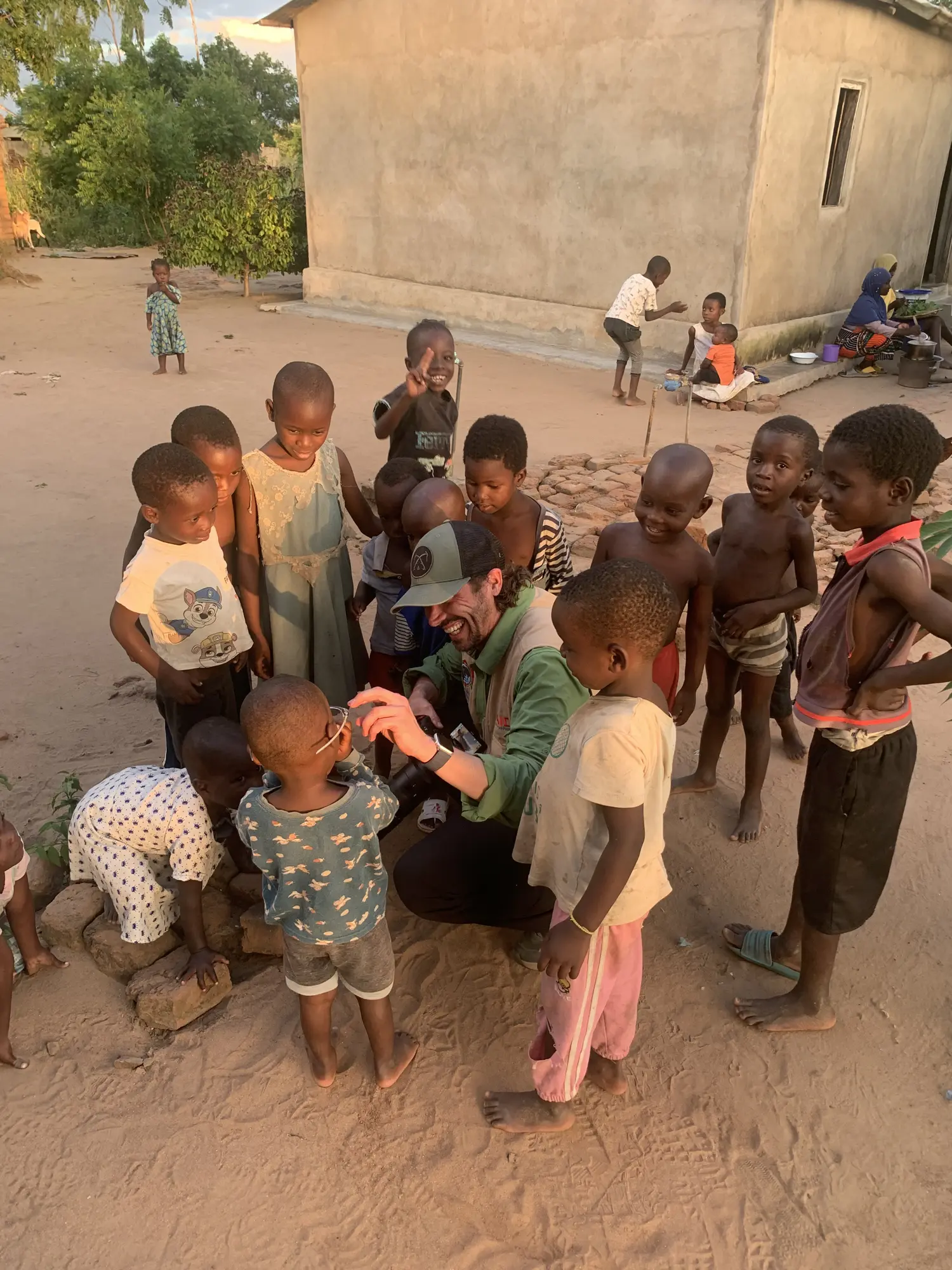 David White sharing a laugh with children on location in Malawi