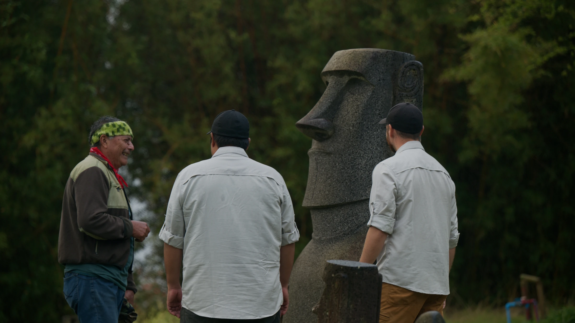 A conversation beside a carved moai on Rapa Nui